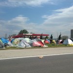 Etwa 20 km südlich von Idomeni liegt ein Camp auf einem EKO-Rastplatz. Es dürfte fast so viele Flüchtlinge beherbergen wie in Piräus. Unter anderem stehen dort 45 Großraumzelte des UNHCR. Die Unterkünfte sind besser und geordneter. Das Camp scheint friedlicher. Vielleicht ist dies der Grund, warum die Presse sich bevorzugt im Camp bei Idomeni aufhält.