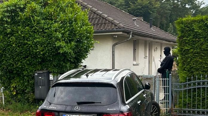 Schwer bewaffnete Sicherheitskräfte bewachen das Haus von Jürgen Elsässer in Falkensee.