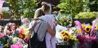 Eine Mutter umarmt ihre Tochter am Gedenkort für die jungen Opfer der Messerattacke eines 17-Jährigen aus Uganda im britischen Southport.
