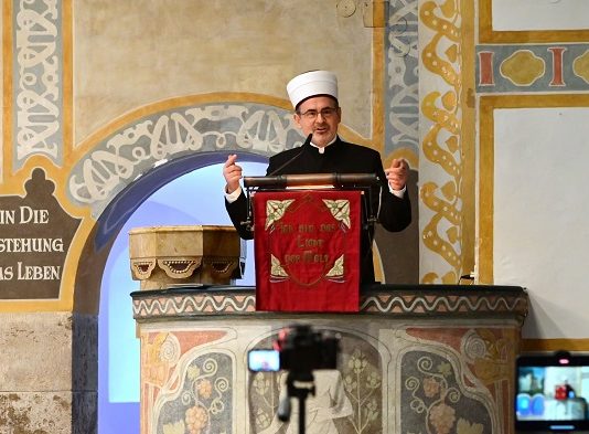 Der umstrittene Imam Bajrambejamin Idriz auf der Kanzel der Münchner Erlöserkirche - direkt neben dem Jesus-Spruch, der konstituierend für das Christentum ist, aber für den Islam eine der größten Blasphemien überhaupt darstellt: "Ich bin die Auferstehung..."