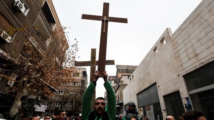 Der Mann, der an Heiligabend mit hoch erhobenen Armen ein Holzkreuz durch die Straßen von Damaskus trug, nachdem radikale Moslems in Sukailabija einen Weihnachtsbaum in Brand gesetzt hatten, ist ein wahrer Held des Jahres 2024.