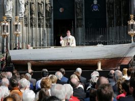 Nur ein Beispiel von vielen: Der Kölner Kardinal Woelki ließ 2016 zum Pontifikalamt an Fronleichnam ein Flüchtlingsboot als Altar vor dem Dom aufbauen.