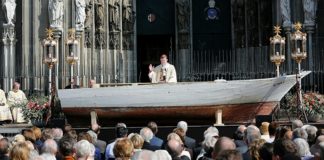 Nur ein Beispiel von vielen: Der Kölner Kardinal Woelki ließ 2016 zum Pontifikalamt an Fronleichnam ein Flüchtlingsboot als Altar vor dem Dom aufbauen.